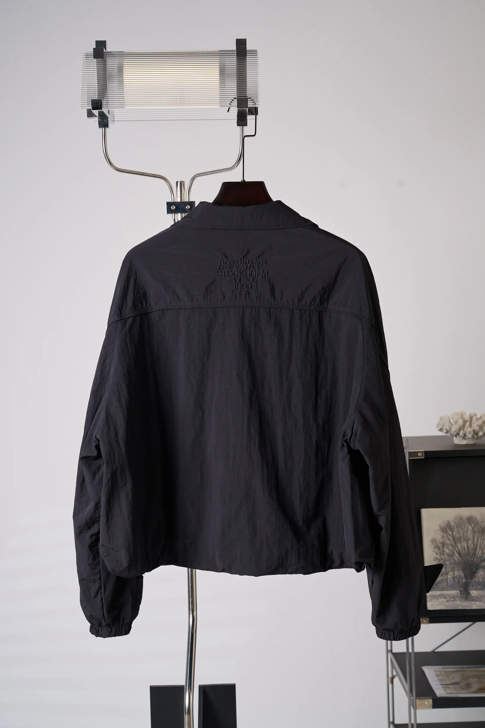 [Real auction] Acne Studios lapel short jacket [In Stock] 32 34 36 The fabric is made of 100% nylon (nylon/polyamide fiber) 75D high-density wrinkled nylon. The fabric has been permanently pressed and shaped by high temperature, and washed with high-pressure wrinkles at the factory to form its own irregular texture, permanently retaining the wrinkled texture, which will not disappear after washing. Matte matte coating removes the plastic glossy surface of nylon itself to create a low-key matte paper feel. Three-proof micro-coating, weak waterproof, anti-fouling, anti-static treatment, not easy to get dust. The interior is made of full-width mesh Breathable nylon lining, which reduces the stickiness of the nylon fabric to the body, improves air circulation, prevents sweating from sticking to the skin, and the zipper does not rub against the skin. The version adopts the raglan split topstitching process, and the front and rear panels are divided diagonally to expose even stitching. The three-dimensional dropped shoulders are loose and the fit is increased to increase the margin of movement. The back neckline is three-dimensional and high-density computer embroidered, and the embroidery lines are dense and not prickly. Customized all-metal matte nylon zipper, Genuine Leather embossed brand letters on the zipper leather tab, zipper tape with same color nylon fit to the body, double-locked reinforcement on both sides of the zipper to prevent pulling and tearing.